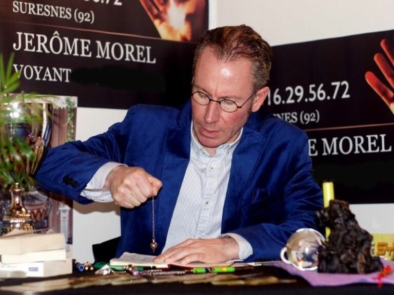 Jérôme Morel voyant montre comment bien tenir la chainette du pendule entre son pouce et son index